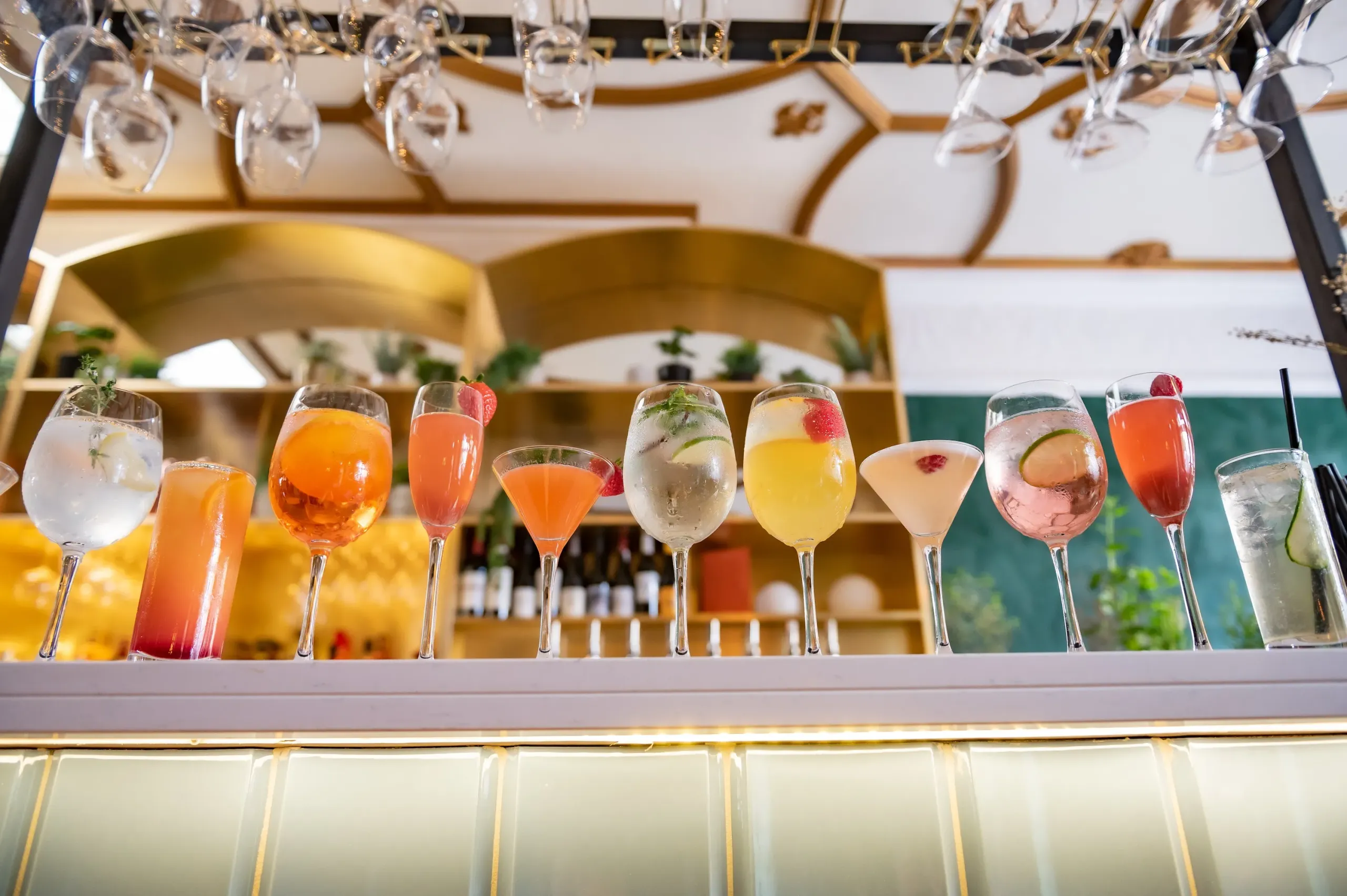 A row of colourful cocktails on the bar at Damson & Wilde