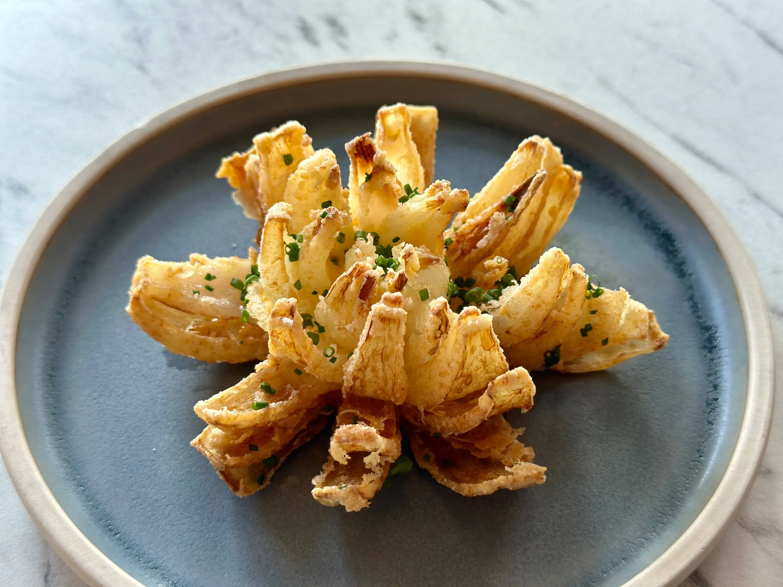 Crispy fried onion on a blue plate