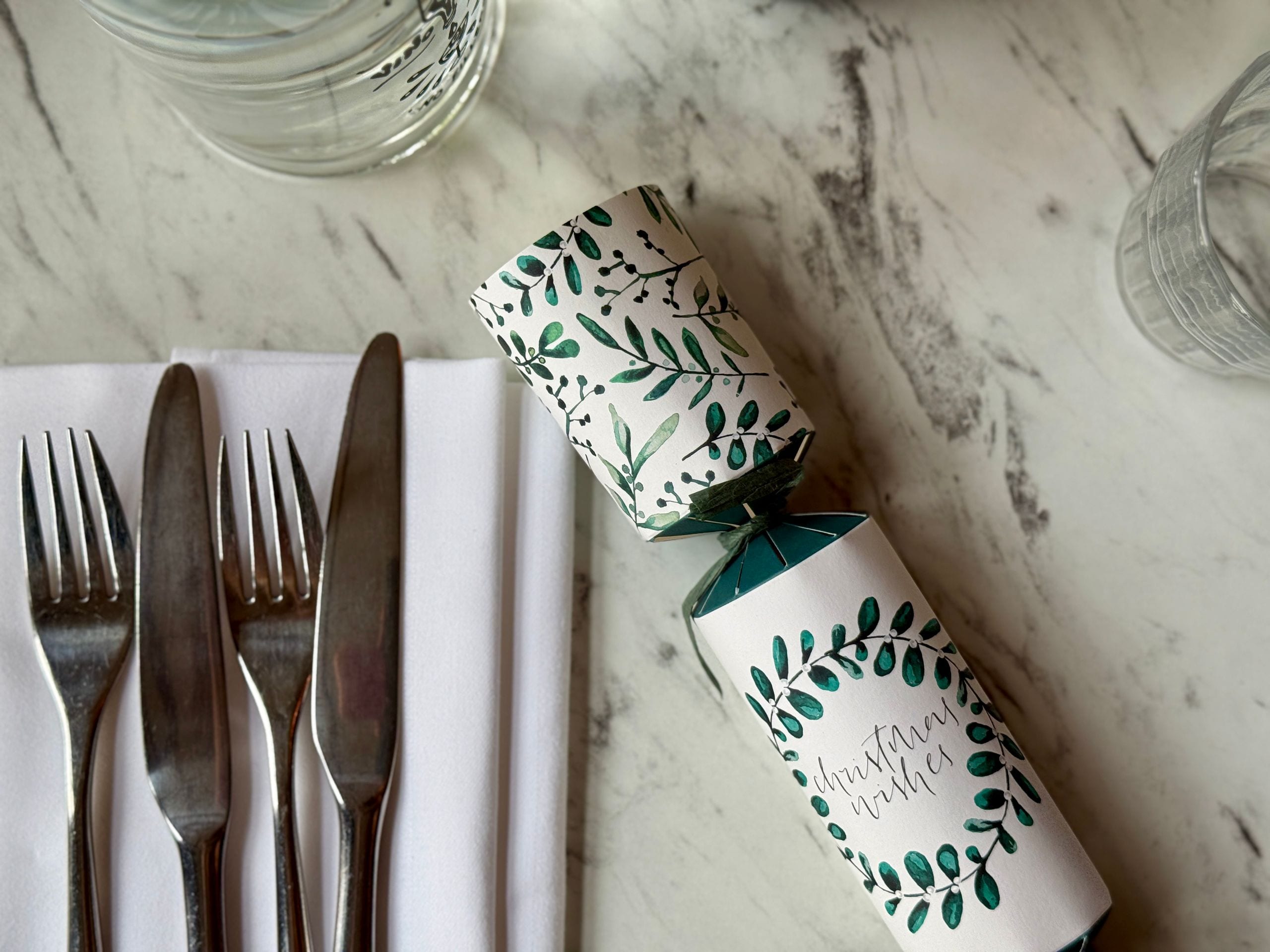 Christmas cracker and cutlery on a marble table at Damson & Wilde
