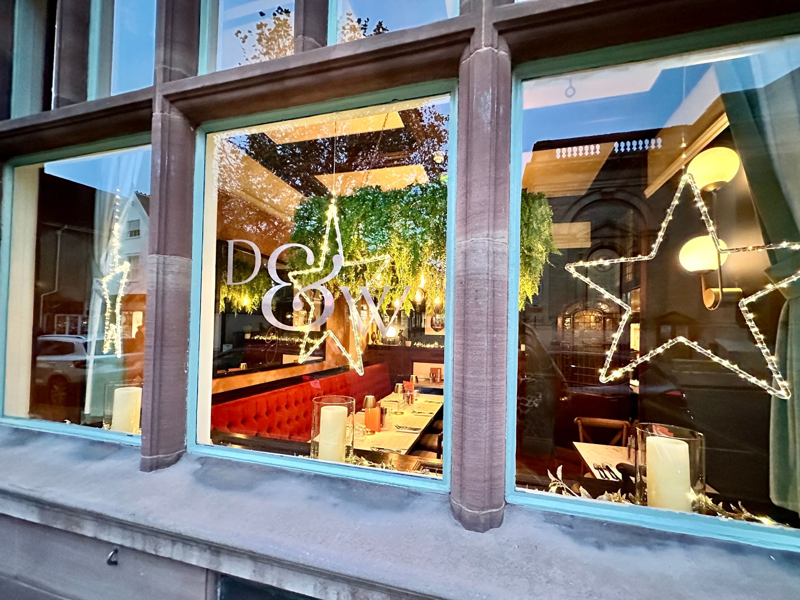 Damson & Wilde lit up for Christmas, seen through the front windows